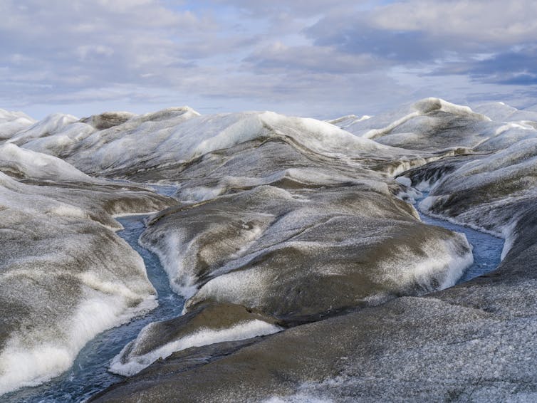 Dark snow with streams running through it.